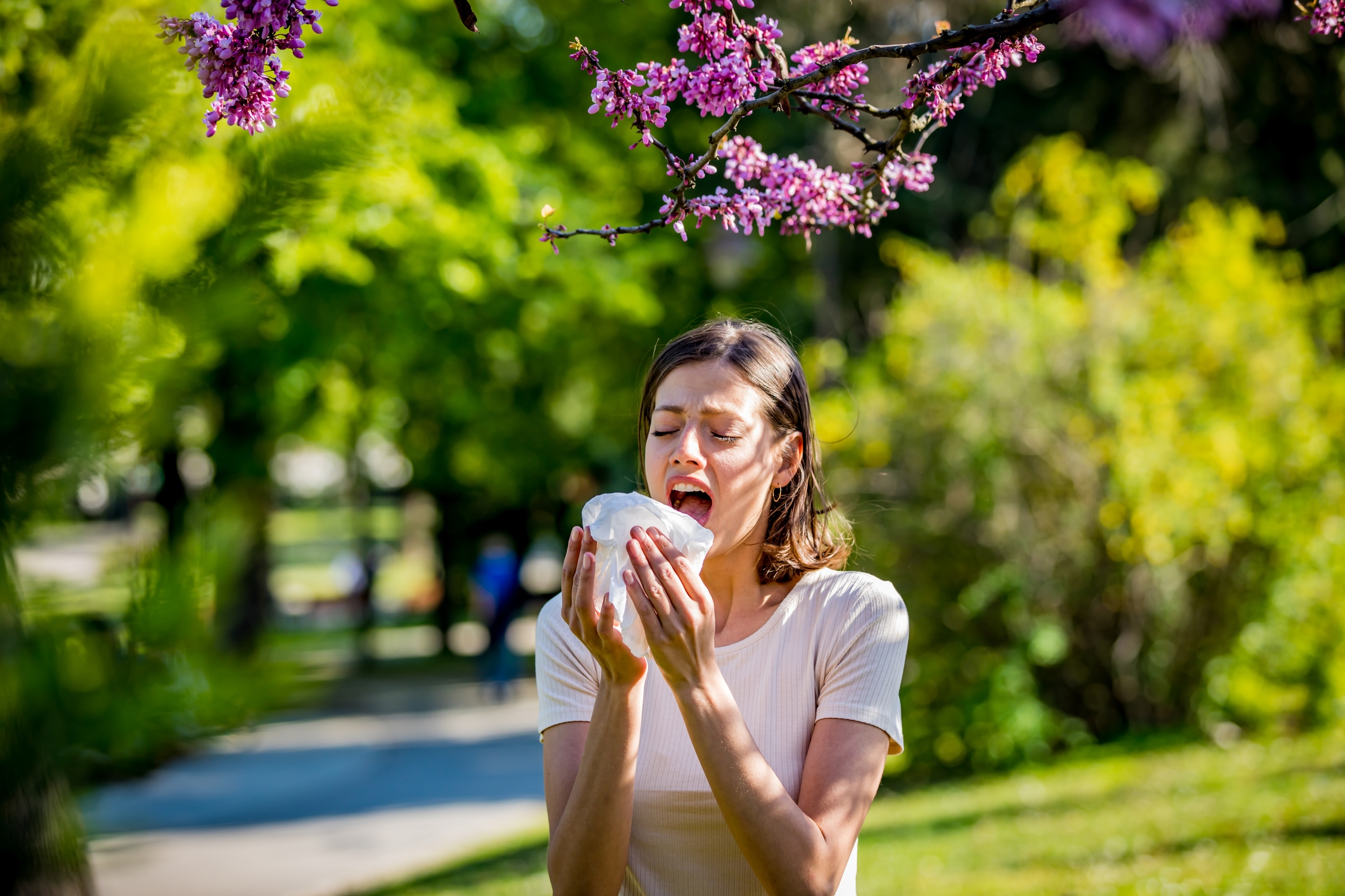 Woman trying to stop sneezing from seasonal allergies