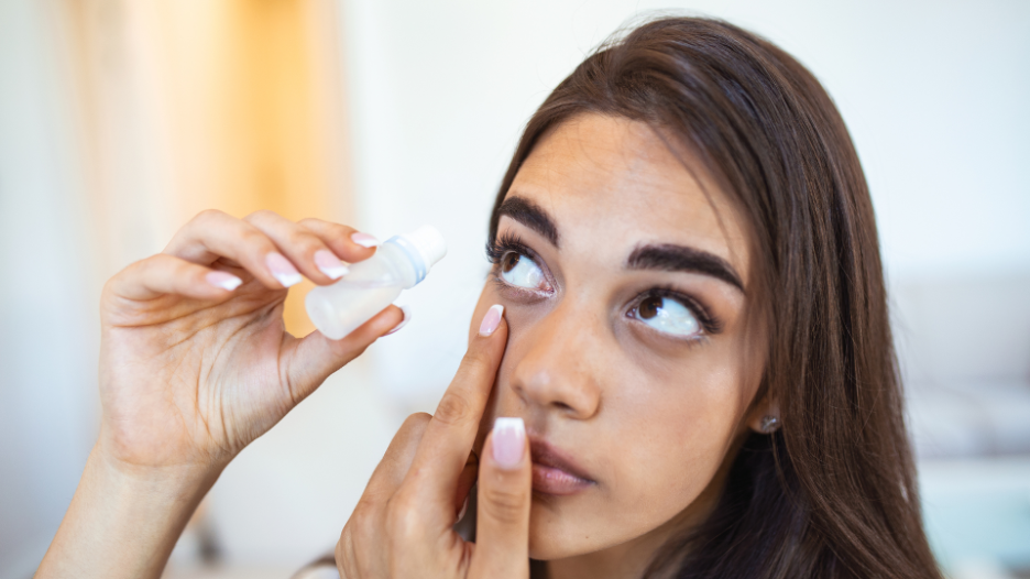 Woman using eye drops to treat eye redness