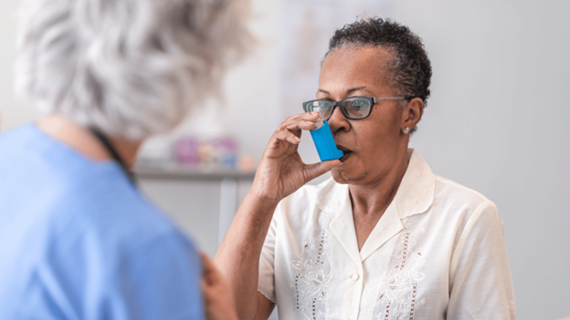 A woman using an asthma inhaler at a CityMD urgent care clinic