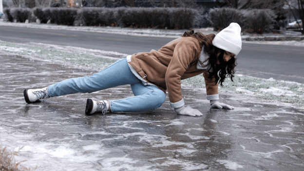 Woman slipping and falling on icy pavement during winter